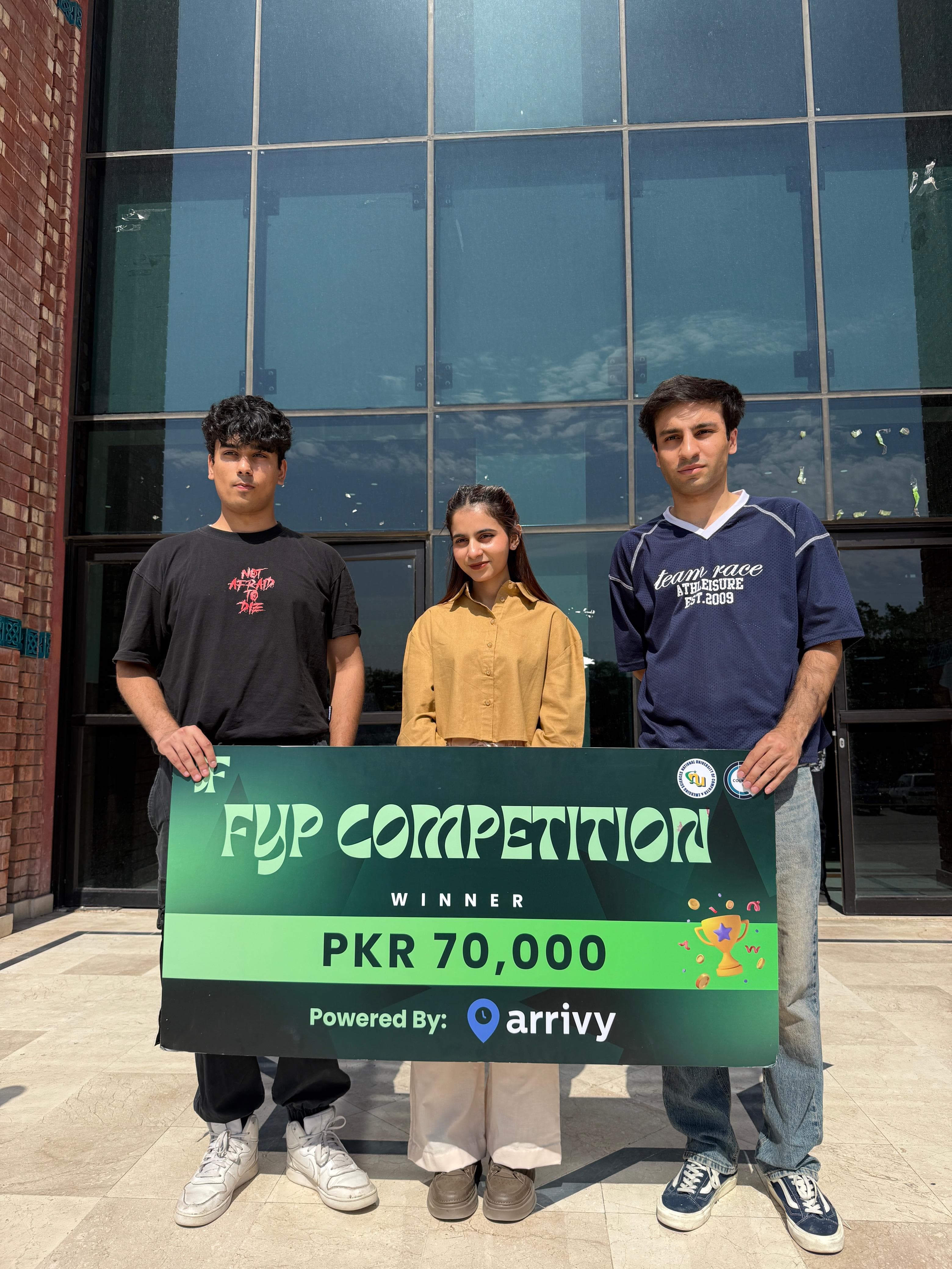 Asma Zahid with her two project teammates holding the FYP Competition winner cheque for PKR 70,000
